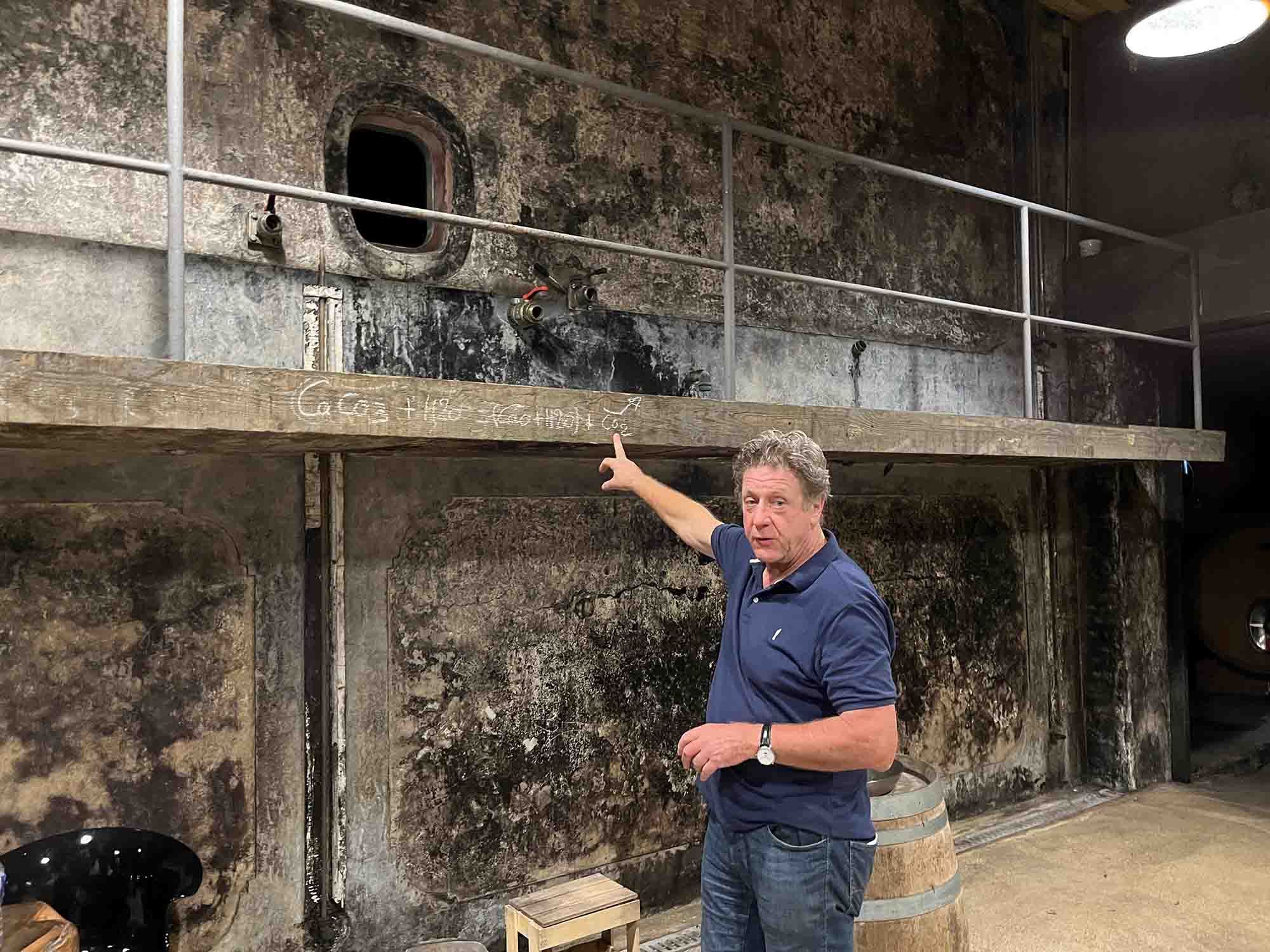 Selosse in cellar pointing out chemical formula he has scrawled in chalk