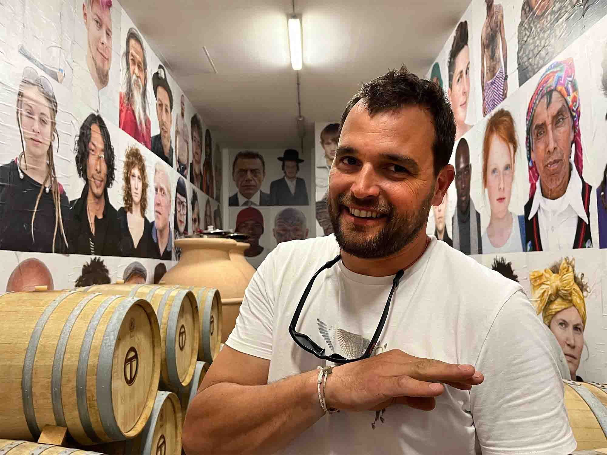 Toscani in cellar with examples of his photo portraits from former career